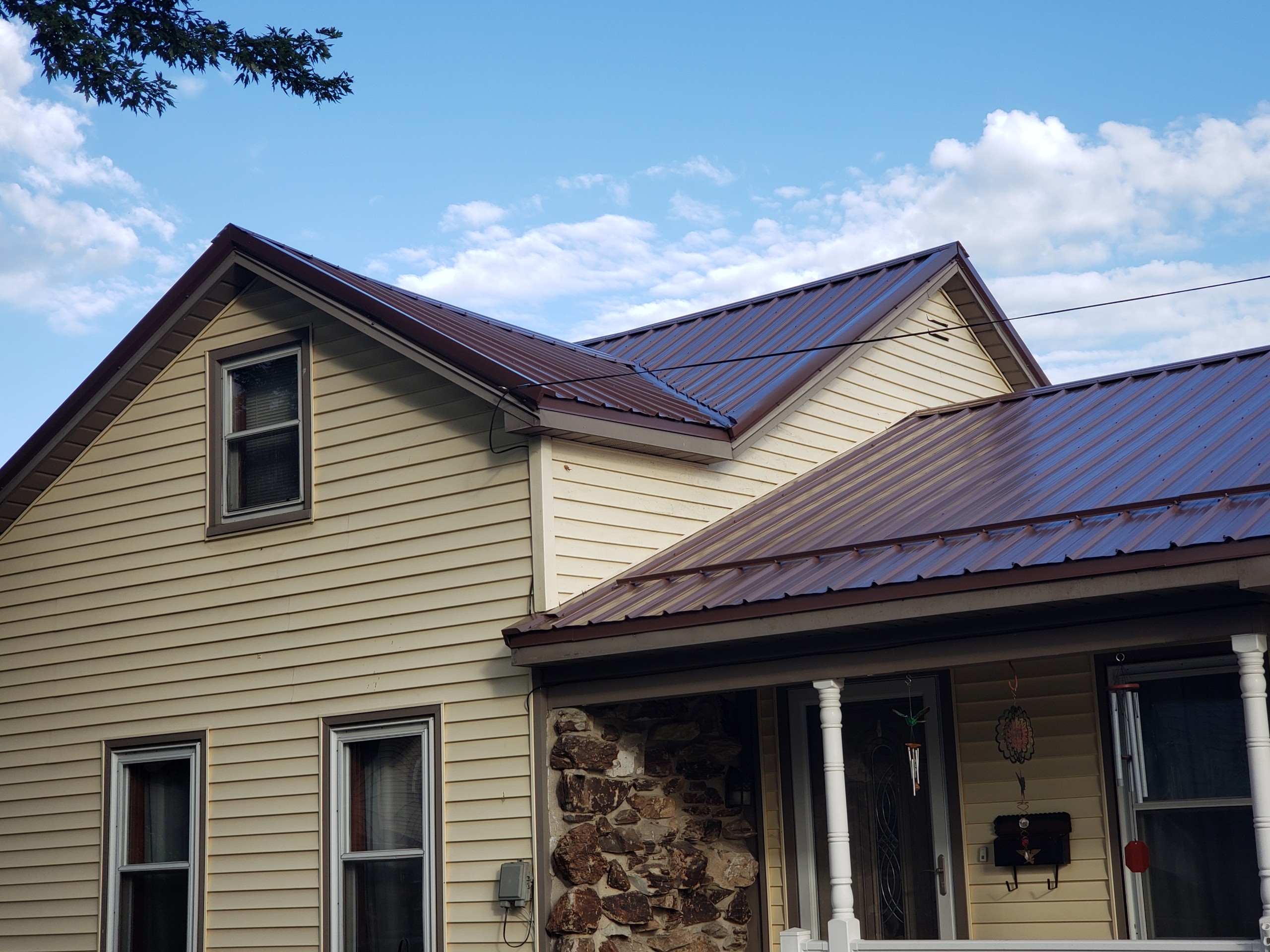 Brown metal roofing on a tan home
